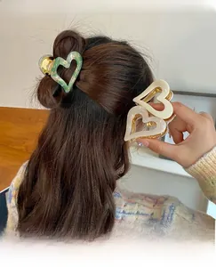 Detail of heart-shaped marble hair claw clip worn on hair for elegant styling