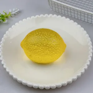 Macro view of a realistic yellow lemon squeeze toy for stress relief on a white plate