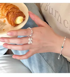 Primer plano de anillo de lazo plateado S925 con piedra de corazón rosa y pulsera