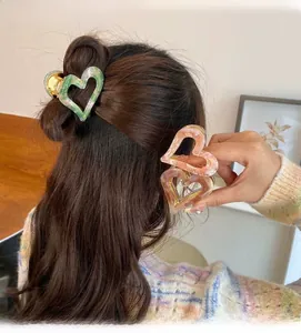 Detail view of retro marble resin heart-shaped claw clips for elegant hair styling