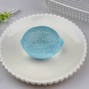 Macro view of a blue translucent lemon-shaped maltose squeeze toy placed on a white plate