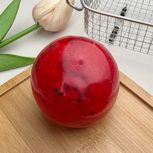 Close-up of a red watermelon smoothie squishy ball for stress relief on a wood board
