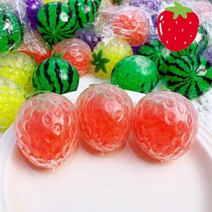 Detalle de cerca de juguete antiestrés de fresa con perlas de agua rojas dentro
