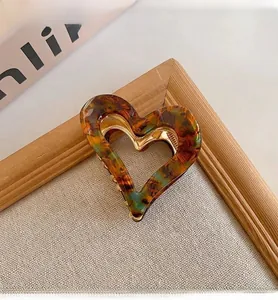 Close-up of retro tortoiseshell heart hair claw clip with elegant marble pattern