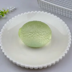 Close-up of green maltose lemon squeeze toy on a white decorative plate