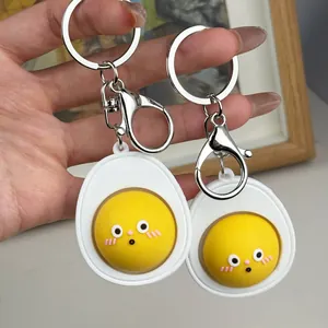 Dos lindos llaveros de huevo de dibujos animados con yema amarilla para aliviar estrés