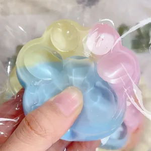 Detailed close-up showing the soft texture of a colorful rainbow cat paw squishy stress toy
