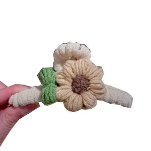 Gros plan d'une pince à cheveux fleur tricotée à la main en texture laine douce