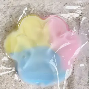 Detailed macro shot of a soft three-color rainbow cat paw squishy toy for stress relief.