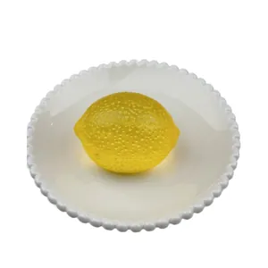 Realistic lemon squishy toy for stress relief placed on a white decorative plate