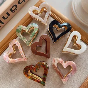 Vintage heart-shaped acetate hair claw clips in various marbled and solid colors.