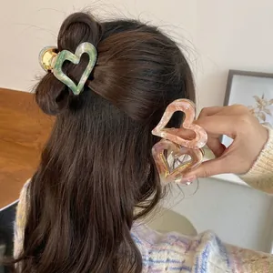 Vintage heart-shaped marbled acetate hair claw clips for women styling in multiple colors.