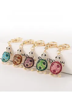 Detail view of colorful rhinestone turtle keychains arranged on a white display box