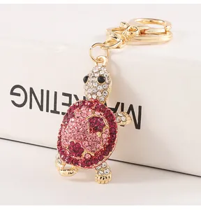 Close-up of a sparkling pink rhinestone turtle keychain charm with gold-tone hardware