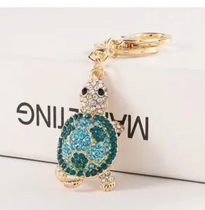 Detailed close-up showing a cute sparkling rhinestone turtle keychain charm for handbags.