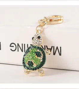 Close-up of a cute turtle keychain decorated with green and clear sparkling rhinestones