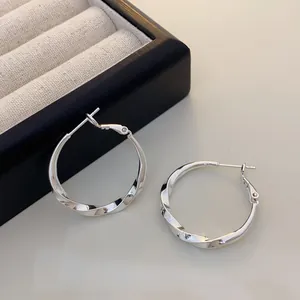 Minimalist silver-colored twisted hoop earrings for women with high-shine finish.