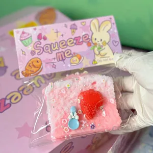 Gedetailleerd beeld van het roze aardbeientoast squishy speeltje in een witte handschoen