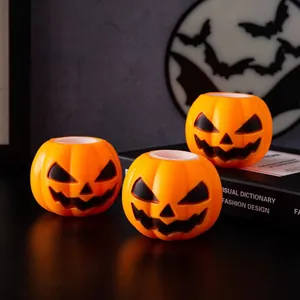 Τρία φωτεινά παιχνίδια κολοκύθας Halloween σε θεματικό σκηνικό διακόσμησης