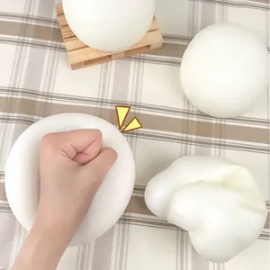 Close-up view of white slow-rebound squishy toy being squeezed to show elasticity