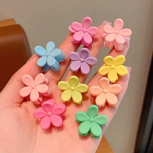 Detailansicht farbenfroher matter Blumen-Mini-Haarklammern für Kinder in der Hand