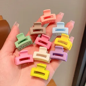 Detailansicht bunter Mini-Haarklammern in Bonbonfarben für Kinder in einer Hand
