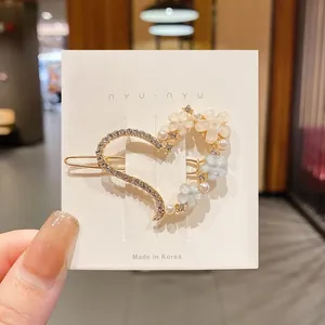 Détail exquis d'une pince à cheveux en forme de cœur avec perles et fleurs en résine.