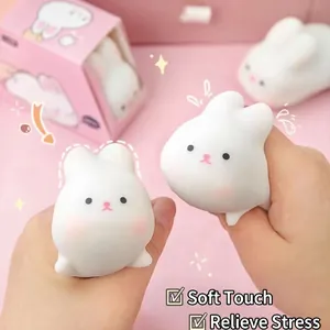 Cute white bunny squishy toy for stress relief held in hands with pink background