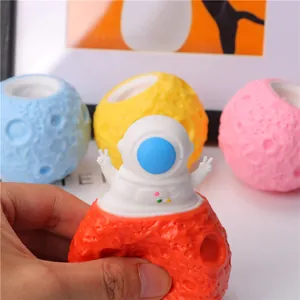 Close-up of hand squeezing astronaut planet toy showing squishy texture and popping effect