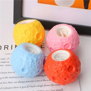 Close-up of four colorful moon-shaped stress relief squeeze toys on a decorative card