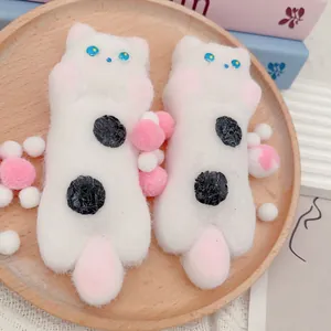 Detaillierte Makroansicht von zwei niedlichen weißen Katzen-Squishy-Spielzeugen auf Holz