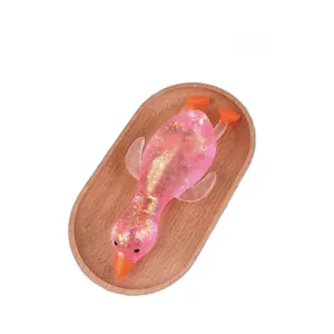 Close-up of pink translucent duck stress relief toy with gold glitter and sequins