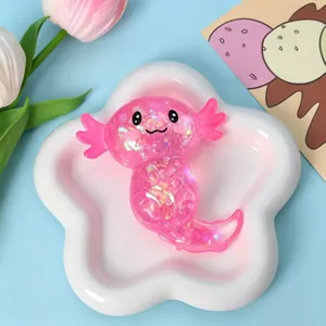 Detailansicht eines rosa Glitzer-Axolotl-Quetschspielzeugs auf einer Sternschale.