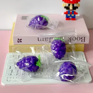 Macro view of purple grape squishy toys for stress relief on a white keyboard