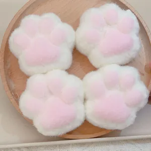 Détail de la texture douce en peluche de quatre jouets anti-stress de patte de chat
