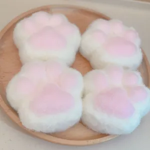 Vue détaillée de quatre jouets anti-stress en peluche douce en forme de patte de chat.