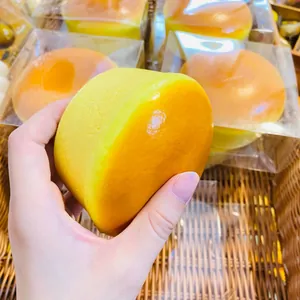 Primo piano di una mano che preme un giocattolo squishy torta al formaggio soft