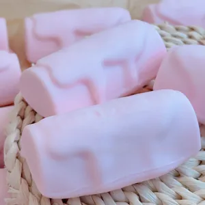 Vue détaillée des jouets à presser roses en forme de barre avec texture souple