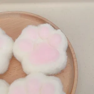 Adorable peluche patte de chat blanche et rose, jouet anti-stress sur plateau en bois