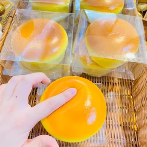 Primo piano di un giocattolo squishy cheesecake a rimbalzo lento premuto dalla mano