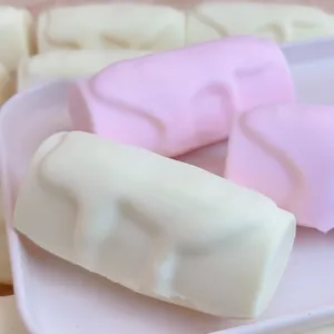 Gros plan sur des jouets squishy à rebond lent en forme de bâtonnets de crème roses et blancs.