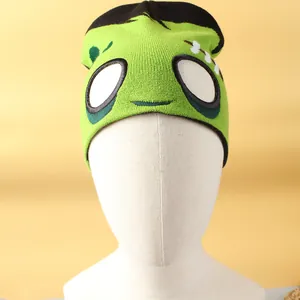 Detalle de gorro de punto de monstruo verde con diseño de ojos para fiestas de Halloween.