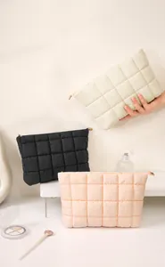 Detailoverzicht van de zachte gewatteerde bubble make-uptas met accessoires