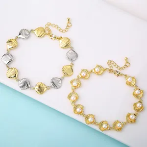 Detail view of gold-plated shell bracelets with elegant pearl inlays and sleek finish.