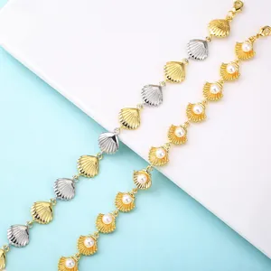 Close-up detail of elegant gold and silver seashell bracelets featuring pearl inlay