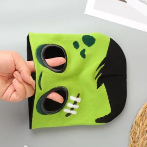 Vista detallada de los agujeros para ojos en un gorro verde de monstruo Halloween