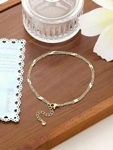 Detailansicht einer vergoldeten zweilagigen Fußkette mit verstellbarem Kettenverschluss.