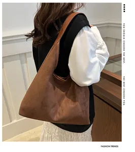 Vista laterale di una borsa tote vintage in pelle scamosciata marrone per pendolari.