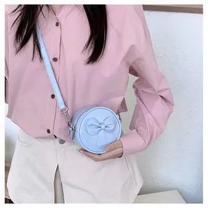 Close-up of a sweet light blue bow mini round bag for girls worn crossbody style