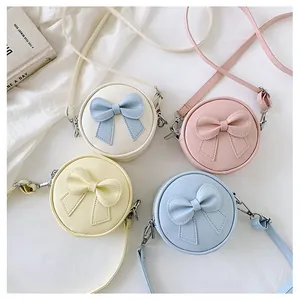 Mini round crossbody bags for girls with cute bow decoration in pastel colors